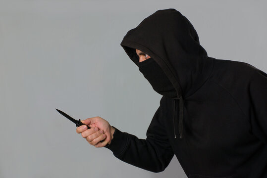 Hombre encapuchado amenazante con una navaja