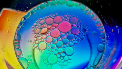 Oil globules creating colorful abstract patterns in soapy water