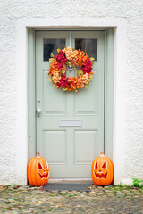 A doorway dressed for the autumn, with halloween jack-o-lanterns, in the entrance