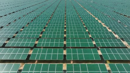 Drone shot of a massive field of green solar panels, showcasing sustainable energy technology and environmental commitment - Powered by Adobe