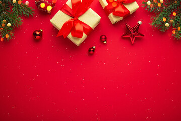 Merry Christmas and Happy Holidays greeting card, frame, banner. New Year. Red Christmas ornaments and gifts on red background top view. Winter xmas festive holiday theme.