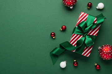 Merry Christmas and Happy Holidays greeting card, frame, banner. New Year. Red Christmas ornaments and gifts, presents on green background top view. Xmas holiday festive theme. Christmas decoration