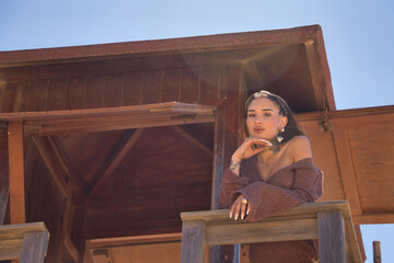 Young, beautiful, Latina woman with tattoos, wearing a brown crochet dress, sweet and tender,...