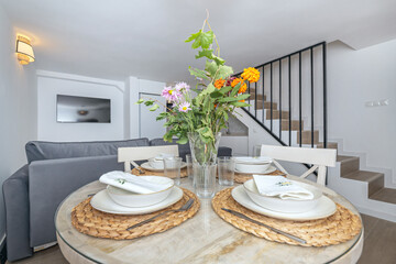 table with folding chairs and a minimalist centerpiece of white and green monstera calla lilies
