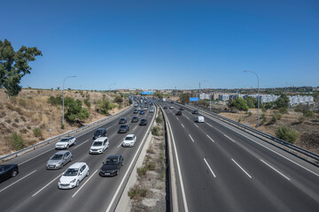 Commercial avenue with heavy traffic and public transport mingling with private vehicles on a weekday