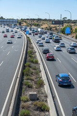National highway with endless lines of cars reflecting the midday sun on their gleaming hoods