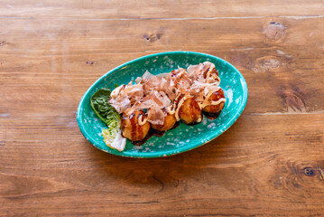 Freshly made takoyaki balls with pieces of fresh octopus, topped with okonomiyaki sauce and Japanese mayonnaise