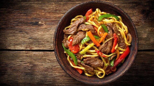 Top view of a Xinjiang Lagman traditional Uyghur noodle dish, hand-pulled noodles topped with stir-fried beef and vegetables bell peppers, tomatoes, carrots, onions, chili served in a rustic bowl
