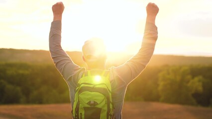 Traveler man with backpack walking raising hands joy of victory. Tourist with backpack travel adventure exploration in nature, vacation adventures in nature. Hiking, active healthy lifestyle. Sports