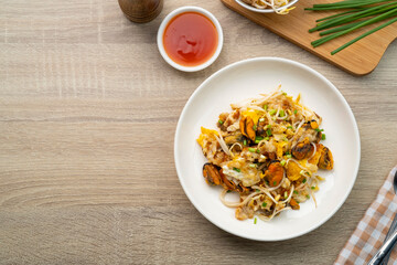 Oyster omelette,Pan fried crispy New Zealand Mussels with bean sprout,Thai crispy pancake in white plate.Top view