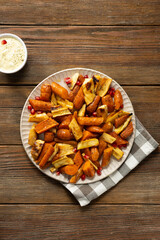 Top view of roasted carrots and parsnips wooden surface