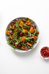 Top view of baked pumpkin and grapes salad light surface