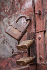 Close-up shot of old rusty locks on a rusty metal door.