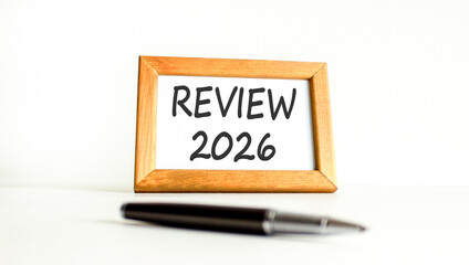 Review 2026 symbol. Concept words Review 2026 on beautiful wooden picture frame. Beautiful white paper background. Beautiful black pen. Business and review 2026 concept. Copy space.
