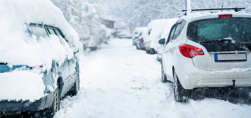 Fototapeta premium Parked car covered with snow during snow storm