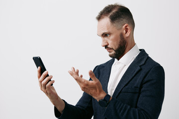A focused business professional man speaks on a mobile device against an isolated colored background, conveying engagement and intent during a remote work scenario.