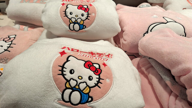Russia, Moscow- 27 October 2025.Stack of plush Hello Kitty-themed blankets featuring colorful embroidered character designs