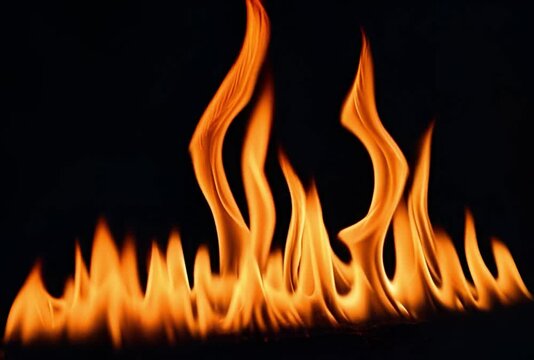 Dynamic fiery flames dance against a stark black background, perfect for intense visual effects or symbolic representations of passion and energy