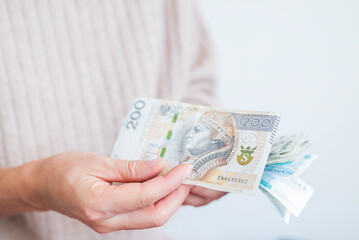 the girl holds in her hands banknotes money polish zlotys and pennies coins salary for payment