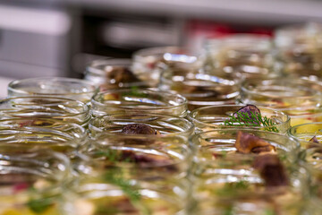 The salad inside the glass in preparation inside a kitchen