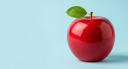 Single bright red apple with green leaf on light blue background fruit food