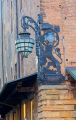 Ornate Street Lamp and Dragon Sign Over Piazza Del Nettuno in Historic Italian Street