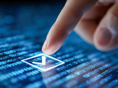 Finger touching glowing check mark on futuristic digital interface with programming code background symbolizing technology verification and approval process