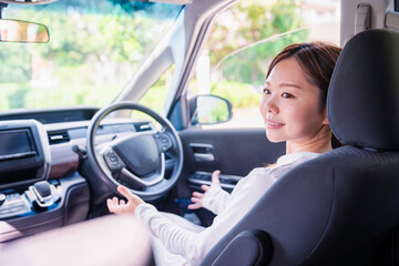自動運転の車で手放し運転をする若い女性