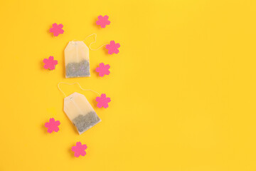 Tea bags with pink labels on yellow background