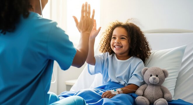 Happy little girl patient giving high-five to a medical professional in a brightly lit hospital room.
