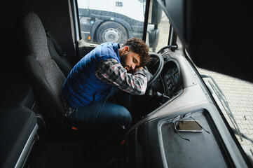 Obraz premium Truck driver sleeping at steering wheel taking a much needed rest