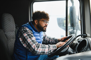 Male truck driver driving commercial vehicle cabin