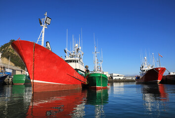 barcos de pesca amarrados en el puerto de getaria un día de cielo azul con sol país vasco...