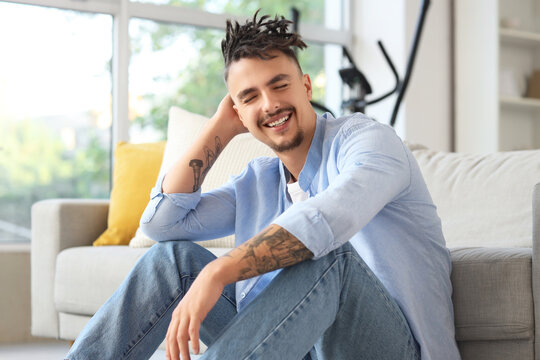 Young man with dreadlocks sitting at home