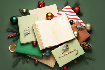 Books with Christmas balls, candy cane and fir branches on green background
