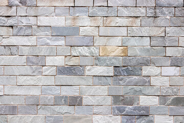 長方形の石材が規則的に積み重ねられた石壁の全面テクスチャ