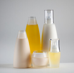 Plastic containers for skincare and beauty products in varied shapes and tones, arranged in a clean, minimalist composition.