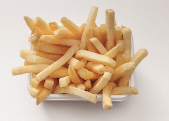 Crispy golden French fries served in a white container, isolated on white background, ready to enjoy.