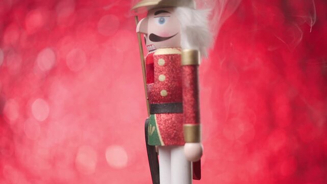 cheerful Toy Nutcracker spins against vibrant red bokeh lights and smoke, ending with portrait perspective