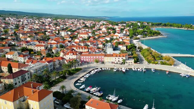 Aerial view of Supetar, Brac Island, Croatia. Picturesque harbor, red-tiled roofs, and turquoise Adriatic Sea under a bright morning sky. Mediterranean beauty.
