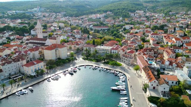 Aerial view of Supetar, Brac Island, Croatia. Picturesque harbor, red-tiled roofs, and turquoise Adriatic Sea under a bright morning sky. Mediterranean beauty.