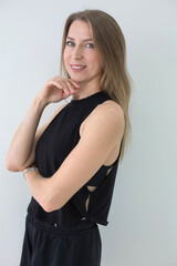 Smiling Woman in Black Athletic Wear Posing Against White Background