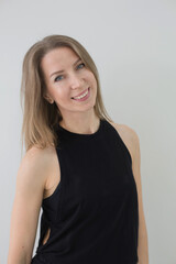 Smiling Woman in Black Athletic Wear Posing Against White Background