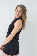 Smiling Woman in Black Athletic Wear Posing Against White Background