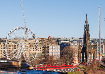 The Scottish city of Edinburgh showing the old church and the Ferris wheel of the Christmas market behind it.