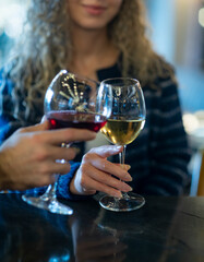  romantic couple toasts with wine glasses at a dimly lit bar or restaurant. 