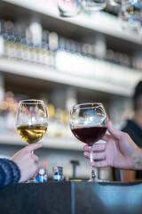  romantic couple toasts with wine glasses at a dimly lit bar or restaurant. 