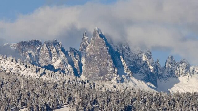 the Minaret peaks near Mammoth Lakes, CA, covered in fresh snow and winter weather clouds. Snow covered Sierra Nevada mountains
