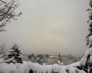 Winter landscape with first snow covering trees and historical building in Chartreuse mountains France