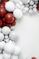 Minimalist balloon decoration with red and white balloons arranged on the left side over a clean white background, creating elegant space for text and festive design layouts.